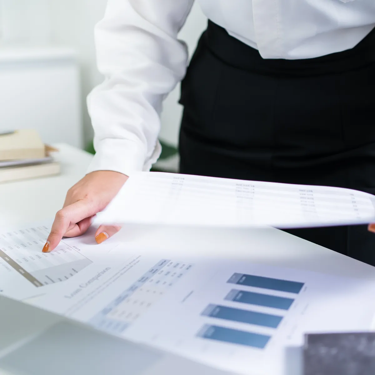 Two colleagues reading a printed financial report together at a desk