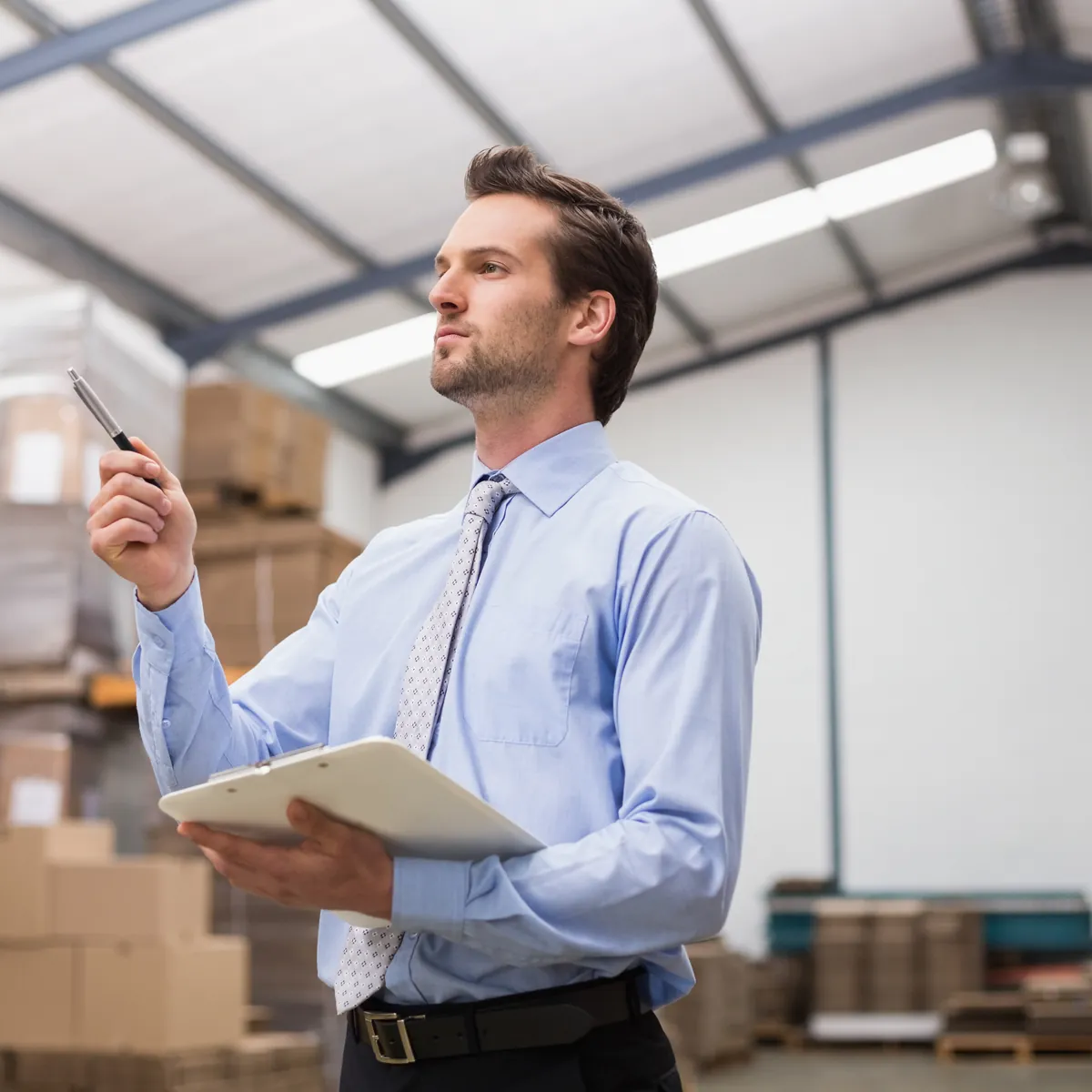 A distributor checking stock against paperwork in a warehouse