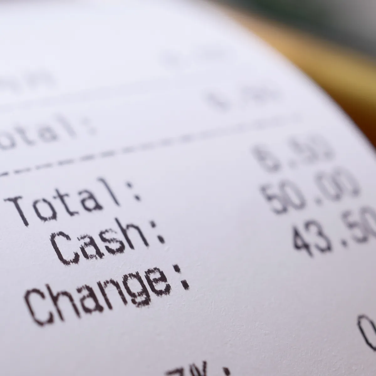 A close-up of a printed receipt showing total, cash and change